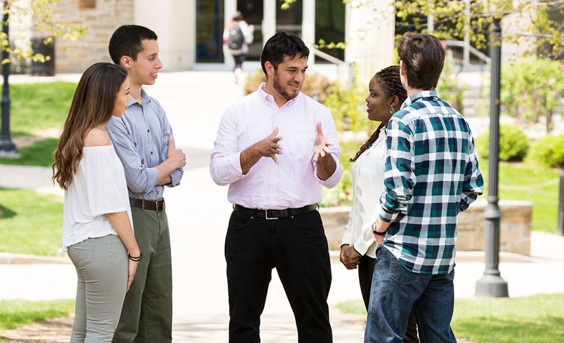 Professor speaking with group of students outside