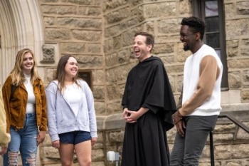 Father Kevin DePrinzio converses with students